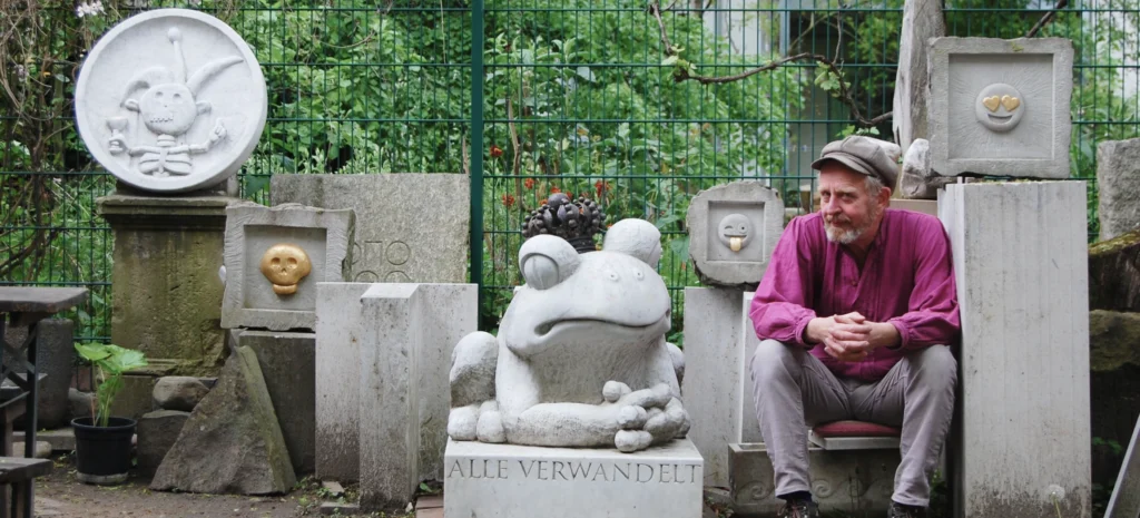 Michael Spengler sitzt zwischen seinen skulpturalen Arbeiten in der Werkstatt
